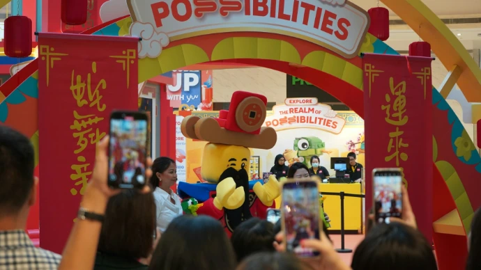People take photos of a mascot during a festival.